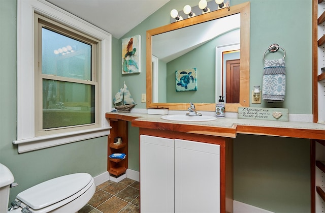 bathroom featuring lofted ceiling, toilet, vanity, and baseboards