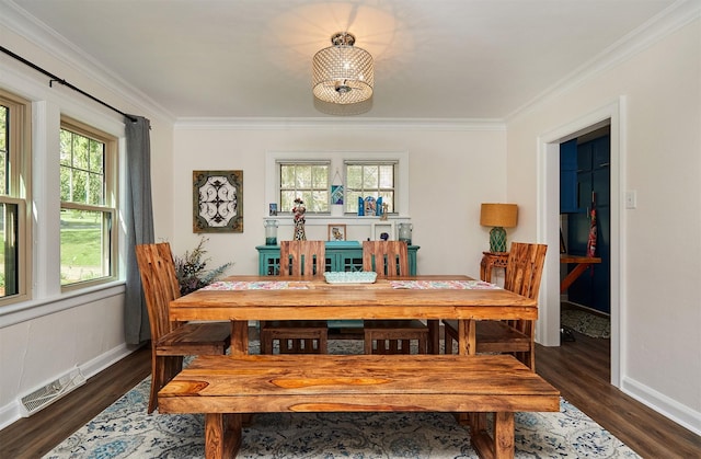 dining room with crown molding, dark wood-style flooring, and baseboards