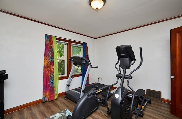 workout area featuring baseboards, wood finished floors, and crown molding