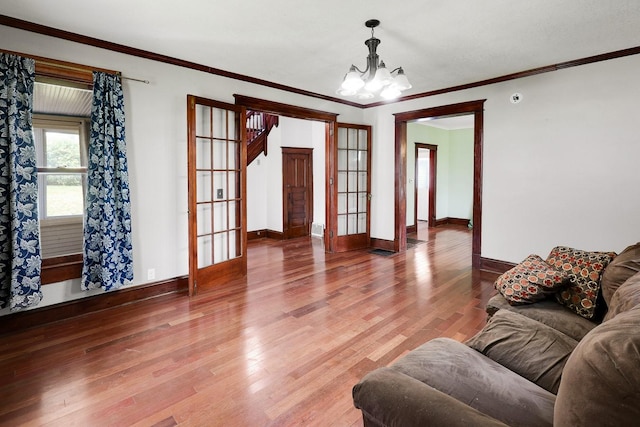 325 E Maple Ave, Ottumwa, IA 52501 - living room with a chandelier, baseboards, wood finished floors, ornamental molding, and french doors