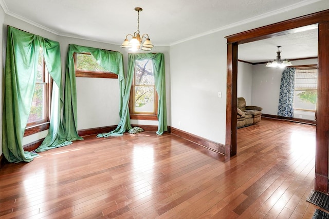 325 E Maple Ave, Ottumwa, IA 52501 - empty room featuring a chandelier, ornamental molding, baseboards, and hardwood / wood-style floors