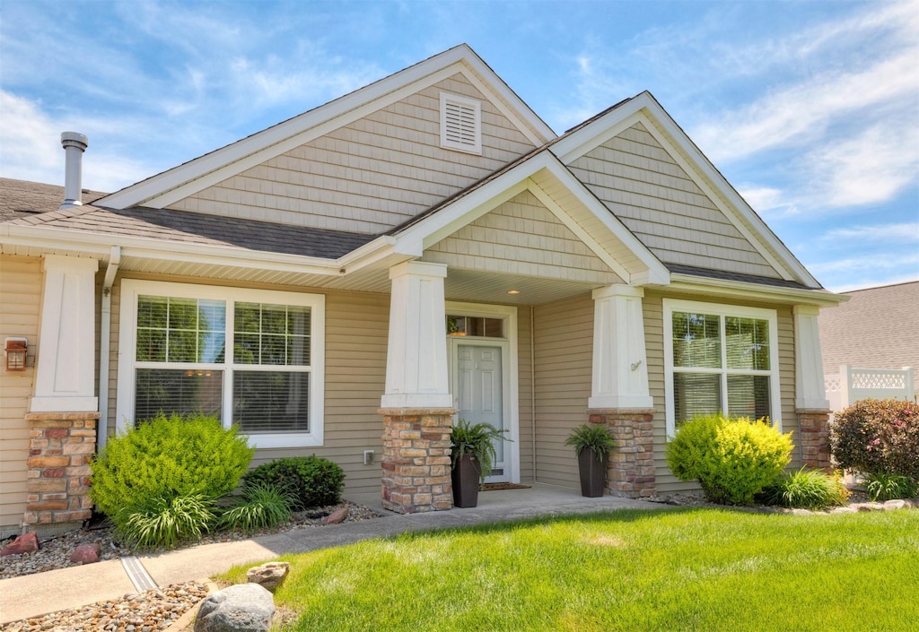 8342 Cody Dr, West Des Moines, IA 50266 - craftsman-style house with stone siding, a shingled roof, and a front lawn