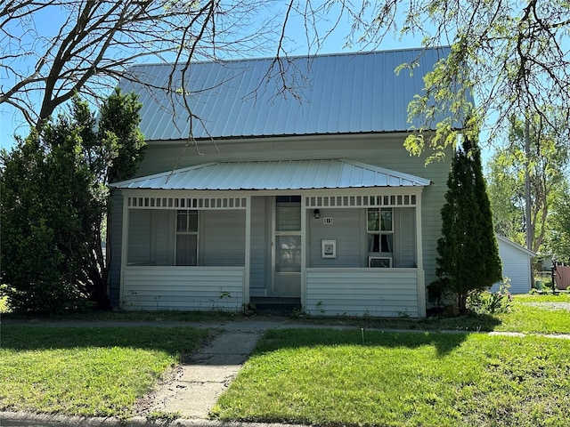 view of front of home with a front yard and metal roof