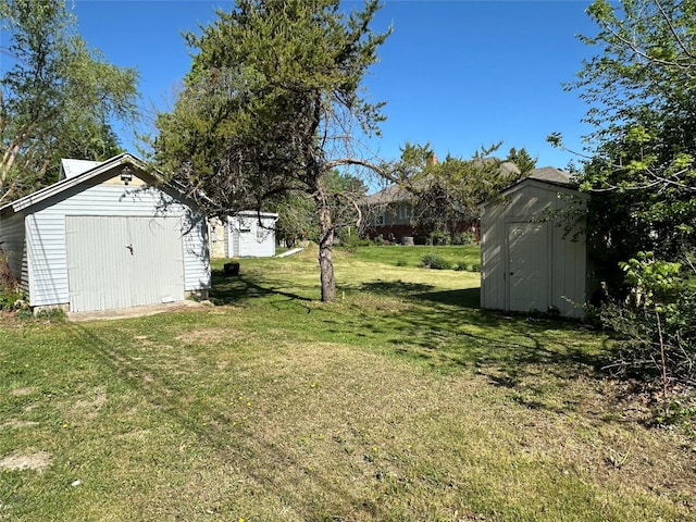 view of green lawn with a storage unit and an outdoor structure