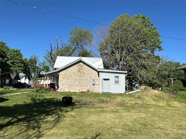 view of side of property featuring stone siding and a lawn