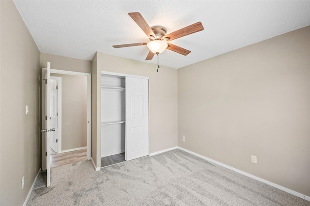 unfurnished bedroom featuring carpet floors, a closet, baseboards, and ceiling fan