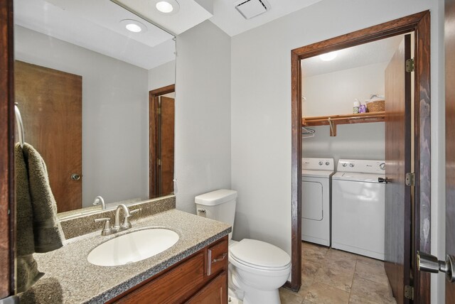 7052 Plum Dr, Urbandale, IA 50322 - bathroom with washing machine and dryer, toilet, and vanity