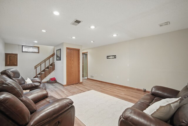 7052 Plum Dr, Urbandale, IA 50322 - living room featuring light wood-style flooring, stairs, recessed lighting, and baseboards