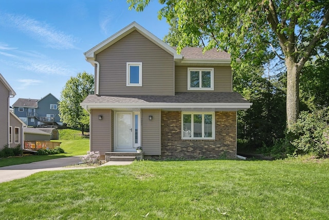 7052 Plum Dr, Urbandale, IA 50322 - view of front facade featuring a front yard, brick siding, and roof with shingles