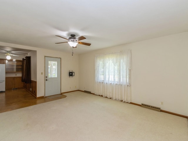 spare room with a ceiling fan, carpet, and baseboards