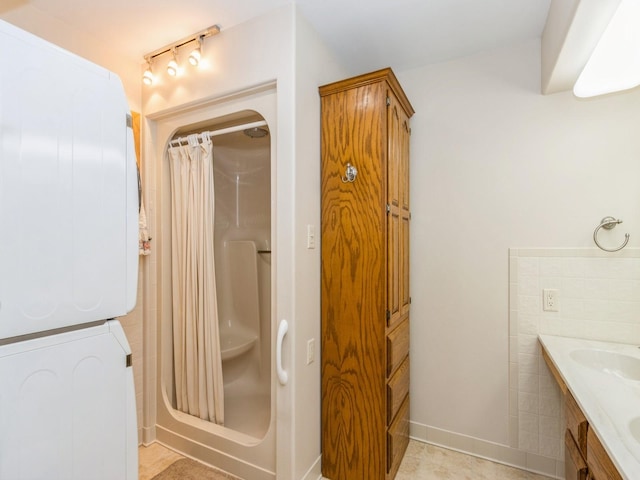 full bath featuring stacked washing machine and dryer, curtained shower, and vanity