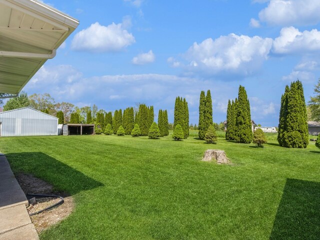 view of green lawn with an outbuilding and an outdoor structure
