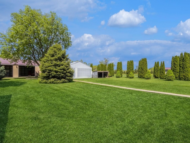 view of grassy yard with a pole building and an outbuilding