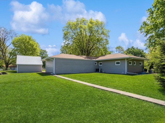 rear view of property with a lawn and cooling unit
