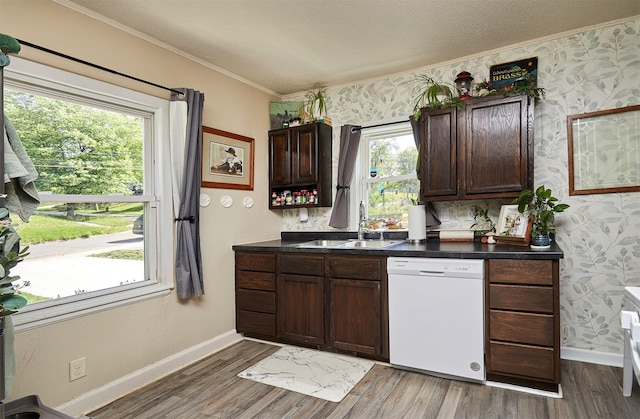 kitchen with dishwasher, a sink, crown molding, baseboards, and wood finished floors