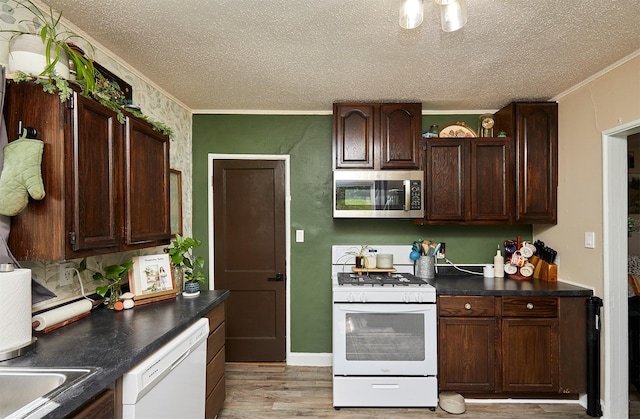 kitchen featuring white appliances, a textured ceiling, ornamental molding, light wood-style flooring, and dark brown cabinetry