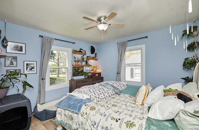 bedroom featuring multiple windows, wood finished floors, and ceiling fan