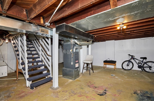 unfinished below grade area with stairs and heating unit