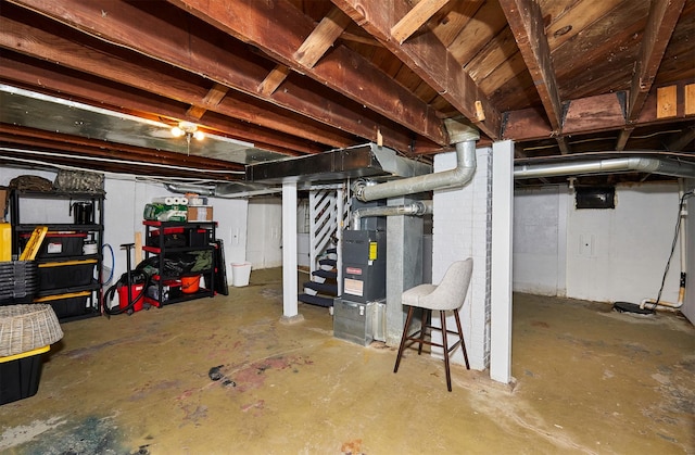 unfinished basement with stairs and heating unit