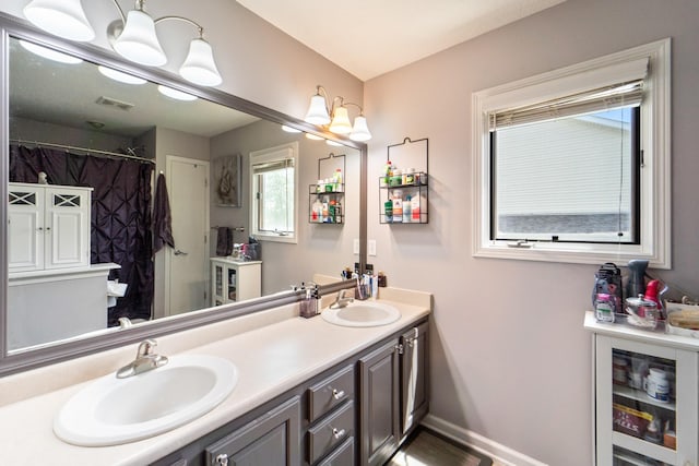 3905 NW 4th St, Ankeny, IA 50023 - bathroom featuring beverage cooler, double vanity, baseboards, and a shower with shower curtain