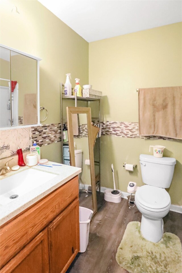 1424 Cleveland Ave, Des Moines, IA 50316 - bathroom with toilet, wood finished floors, vanity, and tasteful backsplash