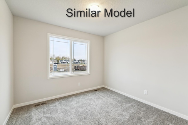 empty room featuring carpet flooring and baseboards