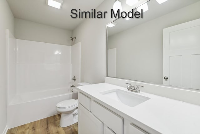 full bath with toilet, wood finished floors, bathing tub / shower combination, and vanity