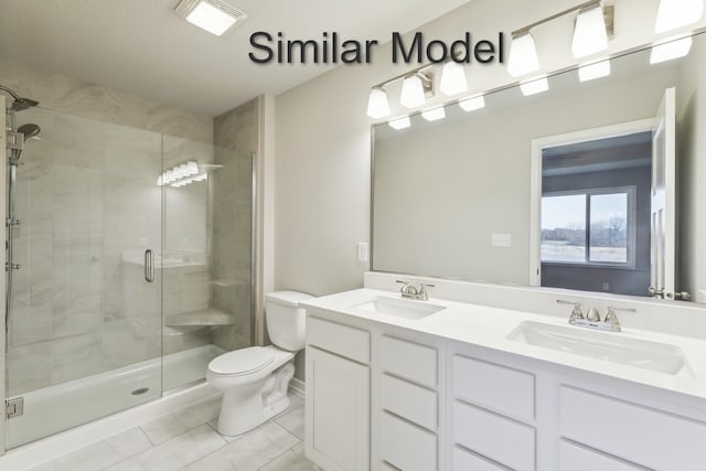 bathroom featuring toilet, a stall shower, and double vanity