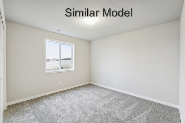 carpeted spare room featuring baseboards