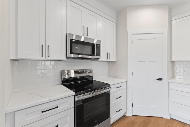 1998 S Warrior Ln, Waukee, IA 50263 - kitchen with appliances with stainless steel finishes, white cabinetry, backsplash, light stone countertops, and light wood finished floors
