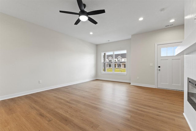 1998 S Warrior Ln, Waukee, IA 50263 - unfurnished living room featuring light wood-type flooring, ceiling fan, baseboards, and recessed lighting