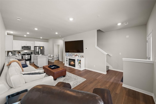 9556 Crestview Dr, West Des Moines, IA 50266 - living room with dark wood-style floors, baseboards, recessed lighting, stairway, and a glass covered fireplace