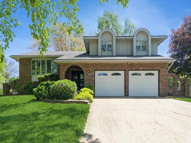 split level home featuring brick siding, concrete driveway, an attached garage, and a front yard