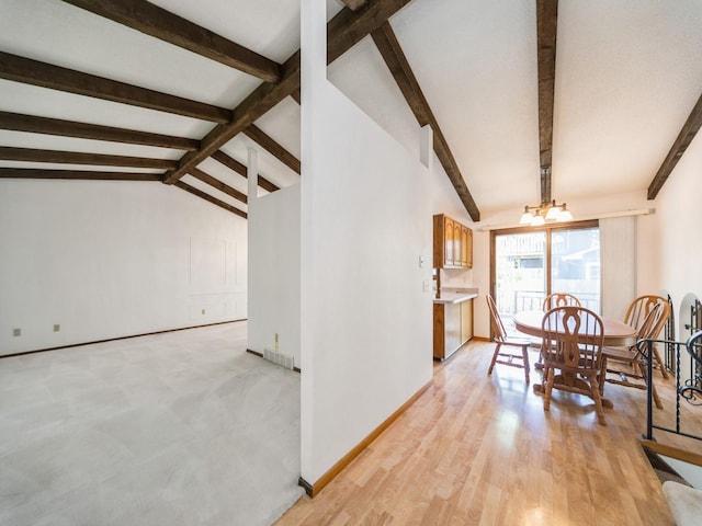 dining space with a chandelier, baseboards, and light wood-style flooring