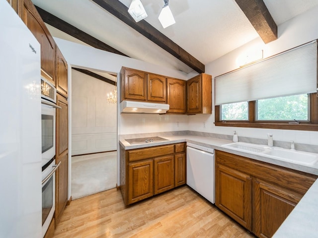 kitchen featuring dishwasher, under cabinet range hood, brown cabinetry, black electric cooktop, and stainless steel oven