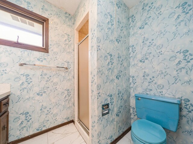 bathroom with vanity, a stall shower, toilet, and baseboards