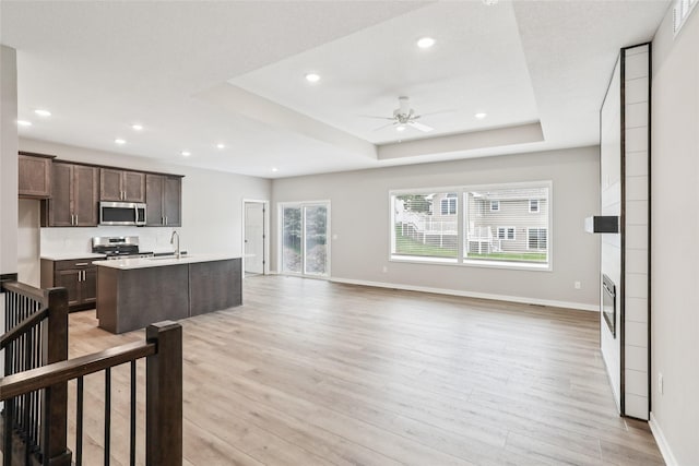 2331 N 8th Ave E, Newton, IA 50208 - kitchen with stainless steel appliances, open floor plan, baseboards, light wood finished floors, and ceiling fan