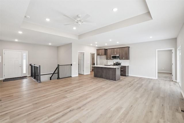 2331 N 8th Ave E, Newton, IA 50208 - unfurnished living room with recessed lighting, a tray ceiling, light wood-type flooring, and a ceiling fan