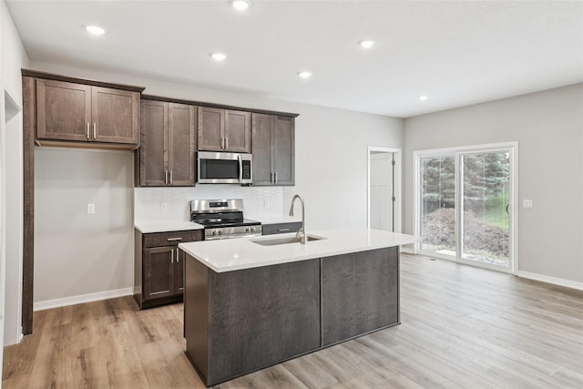 2331 N 8th Ave E, Newton, IA 50208 - kitchen with stainless steel appliances, light wood-type flooring, dark brown cabinets, backsplash, and recessed lighting