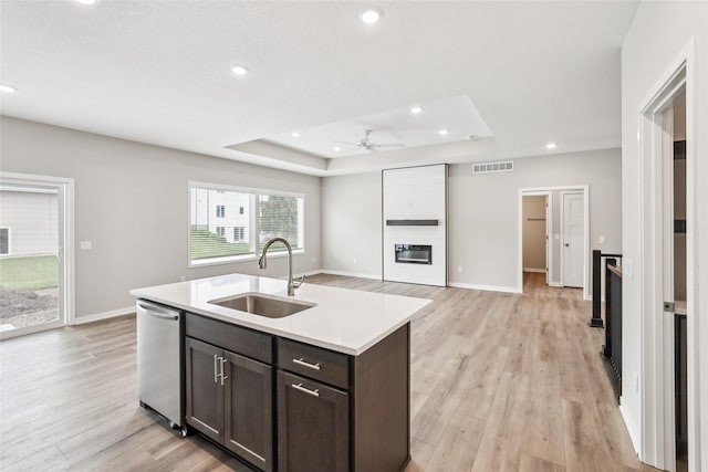 2331 N 8th Ave E, Newton, IA 50208 - kitchen featuring stainless steel dishwasher, a sink, a raised ceiling, light wood-style flooring, and dark brown cabinetry