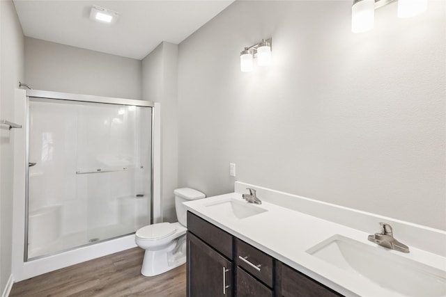 2331 N 8th Ave E, Newton, IA 50208 - full bathroom with a stall shower, toilet, wood finished floors, and double vanity