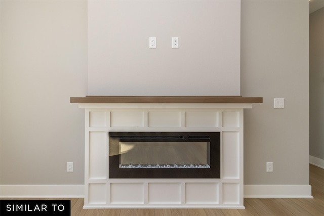 4416 NE 8th St, Ankeny, IA 50021 - detailed view of a glass covered fireplace, wood finished floors, and baseboards