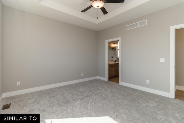 4416 NE 8th St, Ankeny, IA 50021 - unfurnished bedroom featuring carpet flooring, a raised ceiling, ensuite bathroom, baseboards, and ceiling fan