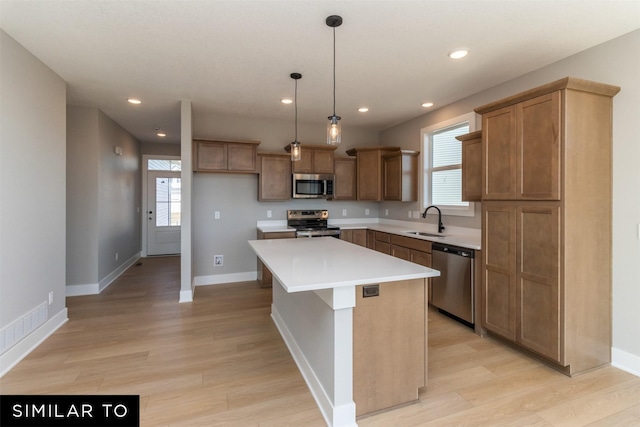 4416 NE 8th St, Ankeny, IA 50021 - kitchen with appliances with stainless steel finishes, a sink, a center island, light wood-style floors, and healthy amount of natural light