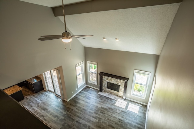 15046 Summit Dr, Clive, IA 50325 - unfurnished living room featuring high vaulted ceiling, a stone fireplace, wood finished floors, and a ceiling fan