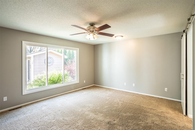 15046 Summit Dr, Clive, IA 50325 - carpeted empty room with ceiling fan, a barn door, and a textured ceiling