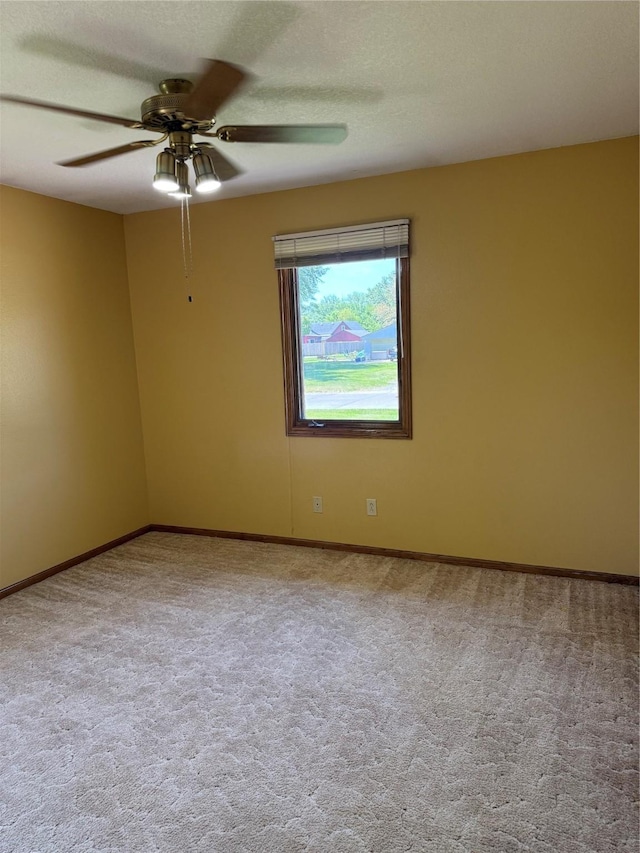 unfurnished room featuring a ceiling fan, carpet flooring, and baseboards