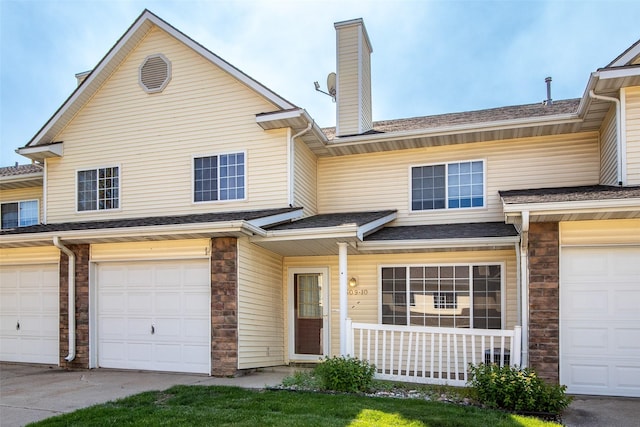 1509 SE Delaware Ave Unit 10, Ankeny, IA 50021 - view of property featuring a garage, a chimney, driveway, and covered porch
