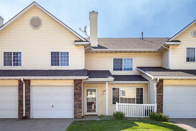 1509 SE Delaware Ave Unit 10, Ankeny, IA 50021 - view of property featuring a chimney, a porch, a shingled roof, an attached garage, and concrete driveway