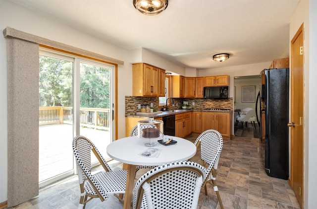 10476 Ricardo Rd, Clive, IA 50325 - kitchen featuring black appliances, stone finish floors, decorative backsplash, a sink, and brown cabinetry